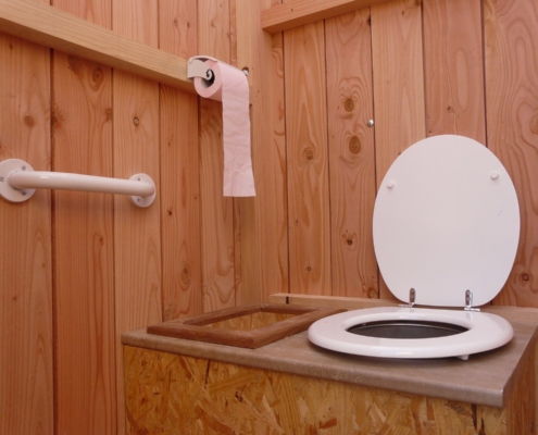 Photo représentant l'activité d'assainissement d'OASURE. On observe l'intérieur d'un toilette sèche en bois bien propre.