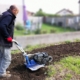 Photo représentant une ancienne activité d'OASURE de service à la personne. Elle est illustré par un salarié en train de passé le motoculteur dans un jardin.