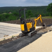 Ouverture d'une tranchée d'ancrage avec une mini pelle pour la mise en place d'une toile pour l'aménagement de talus